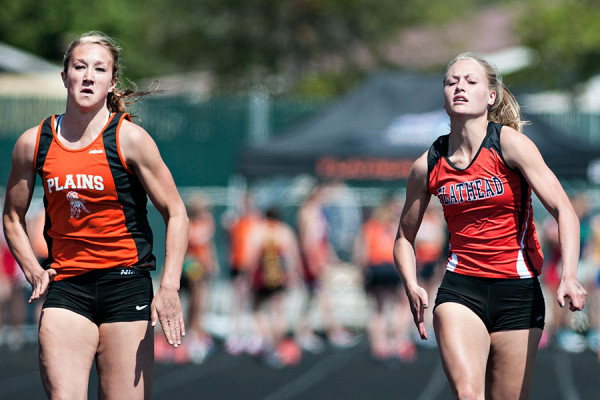 Plains' Hailey Phillips, left, and Flathead's Monica White battle in the 100-meter dash during the 40th annual Archie Roe track and field meet at Legends Stadium in Kalispell on May 2, 2015. Greg Lindstrom | Flathead Beacon