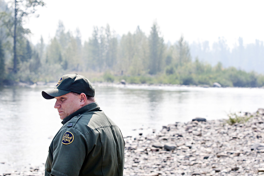 Richard K. Stratton, Patrol Agent in Charge, looks out over the North Fork Flathead River at the Canadian Border on Aug. 25, 2015. Greg Lindstrom | Flathead Beacon