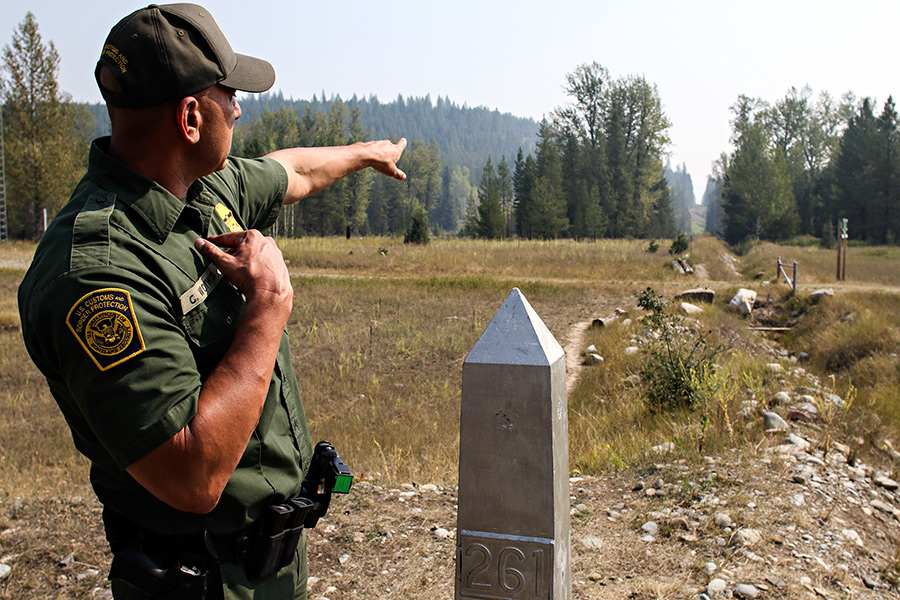 Border Patrol agent Chris Woywod points to the slash line along the U.S. and Canadian border on Aug. 25, 2015. Greg Lindstrom | Flathead Beacon
