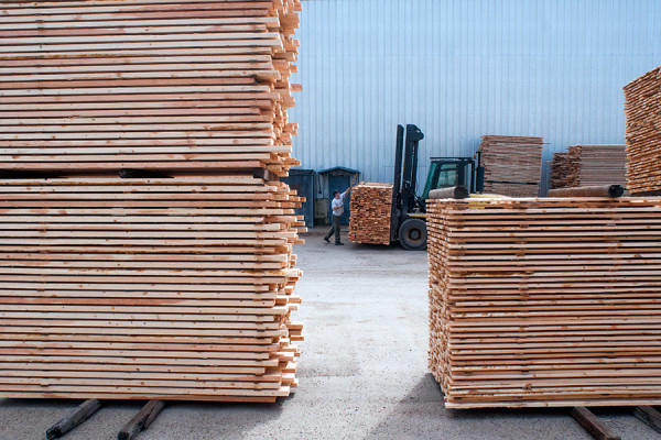 An employee organizes stacks of lumber at the Plum Creek Evergreen facilities. Beacon File Photo
