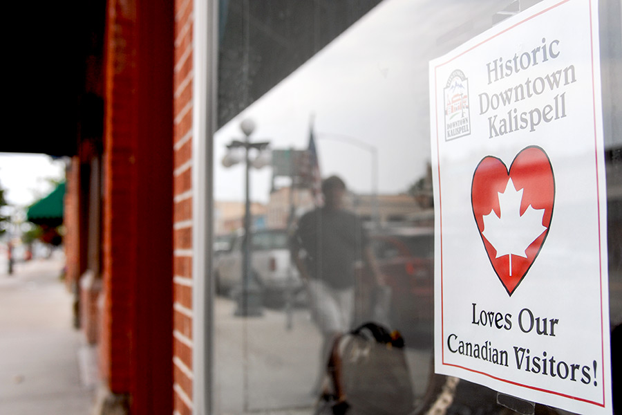 A sign welcoming patrons from Canada is seen in the window of The Re-Finery on Main Street in downtown Kalispell. Beacon File Photo