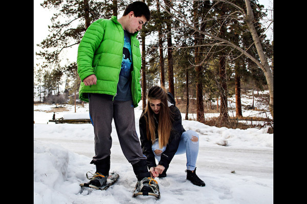 Katey Deist helps her brother Dusty put on his snowshoes . Greg Lindstrom | Flathead Beacon