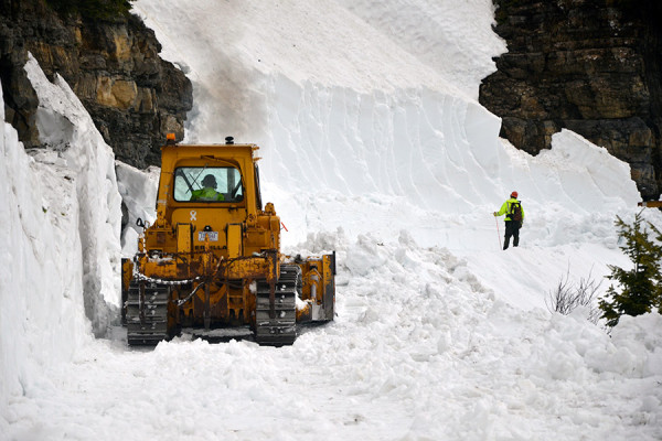 A worker pushes snow off Going-to-the-Sun Road as his spotter watches in Glacier National Park in 2011. Beacon File Photo