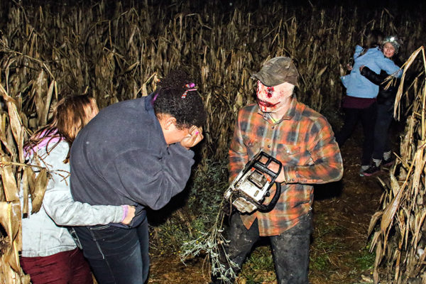 Caden Baxter, center, haunts the Fritz corn maze with a chainsaw on Oct. 22, 2016. Greg Lindstrom | Flathead Beacon