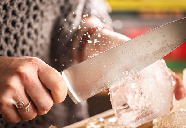 Meaghan Schmoll carving ice for a cocktail